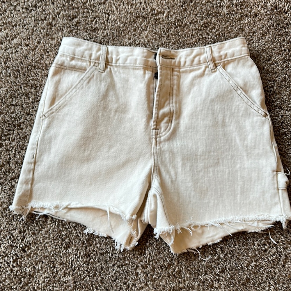 Size 28 Pacsun cut-off shorts with me on side of leg.